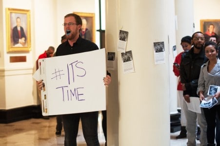A student protests inside Grawemeyer Hall.
