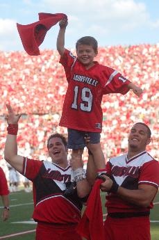 Nolan Coy is hoisted up by Cardinal cheerleaders in celebration of the Cards crushing the Canes