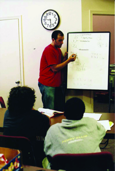 PHOTOS BY ANTONIO LOSAVIO/LOUISVILLE CARDINAL Students in a west Louisville school work with tutors in their math class. A new partnership program in which U of L will be helping is aimed at bolstering educational programs and providing expanded social services to areas of the city with high crime rates, poor employment fi gures and growing numbers of health problems.
